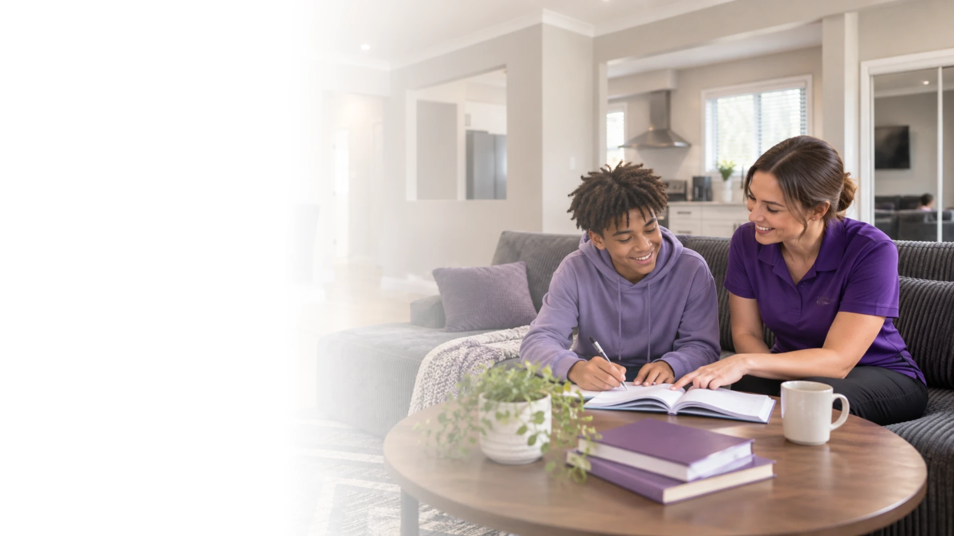 A young person studying with support from a caregiver